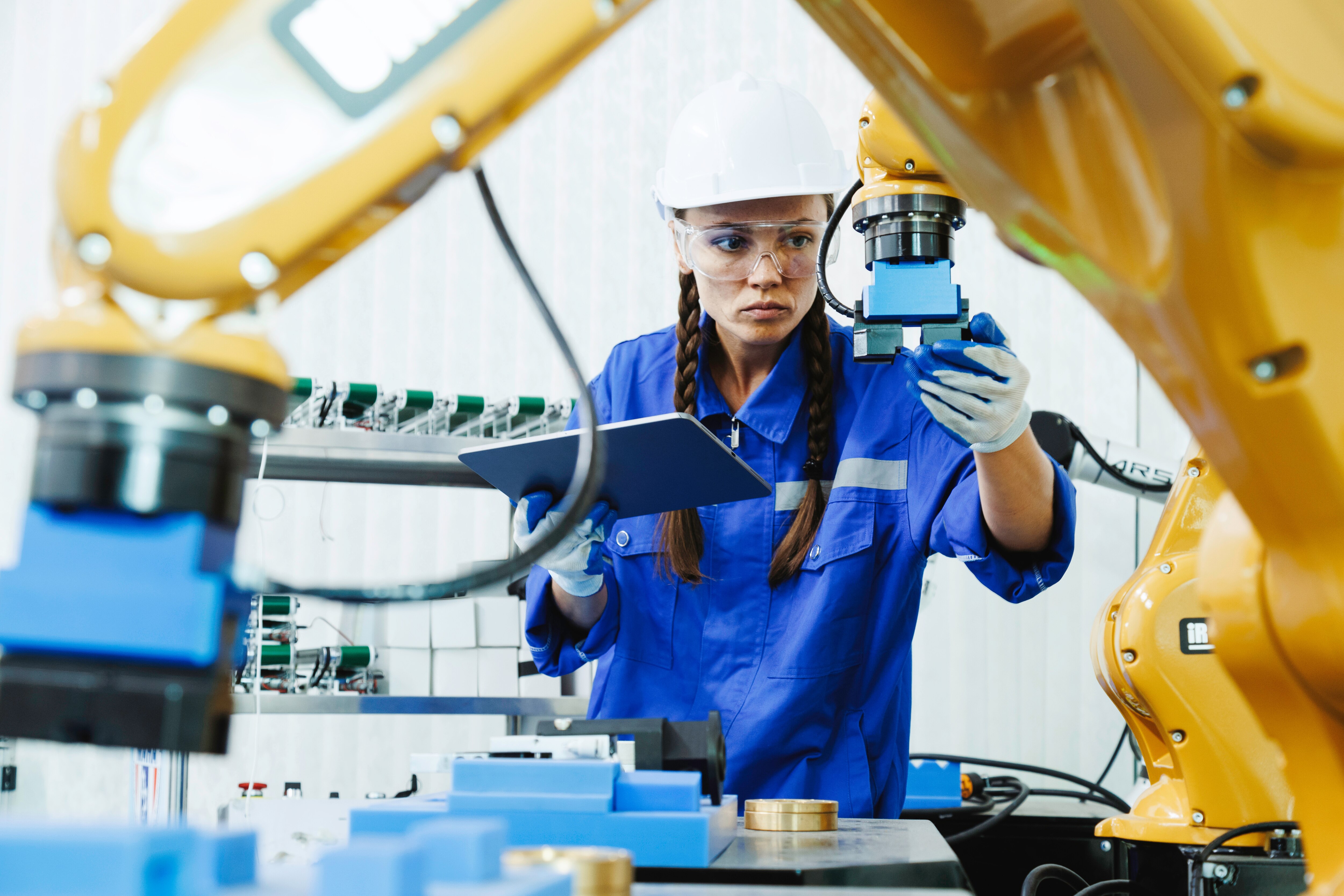 female employee in hardhat checking equpiment