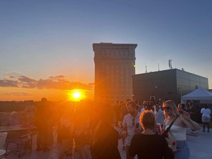 people wandering around Michigan Central Station building at sunset