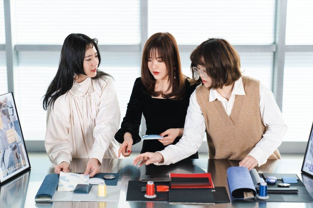 three women discussing fabric opetions