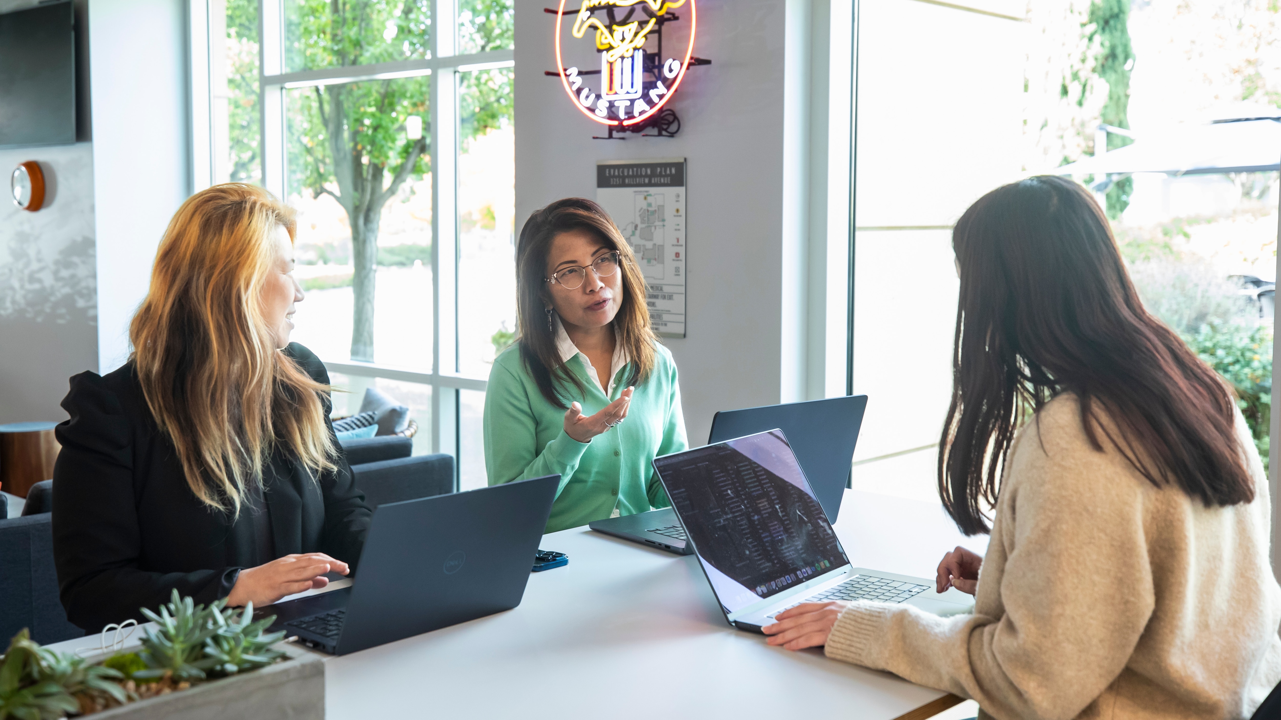Team members collab orating around a laptop
