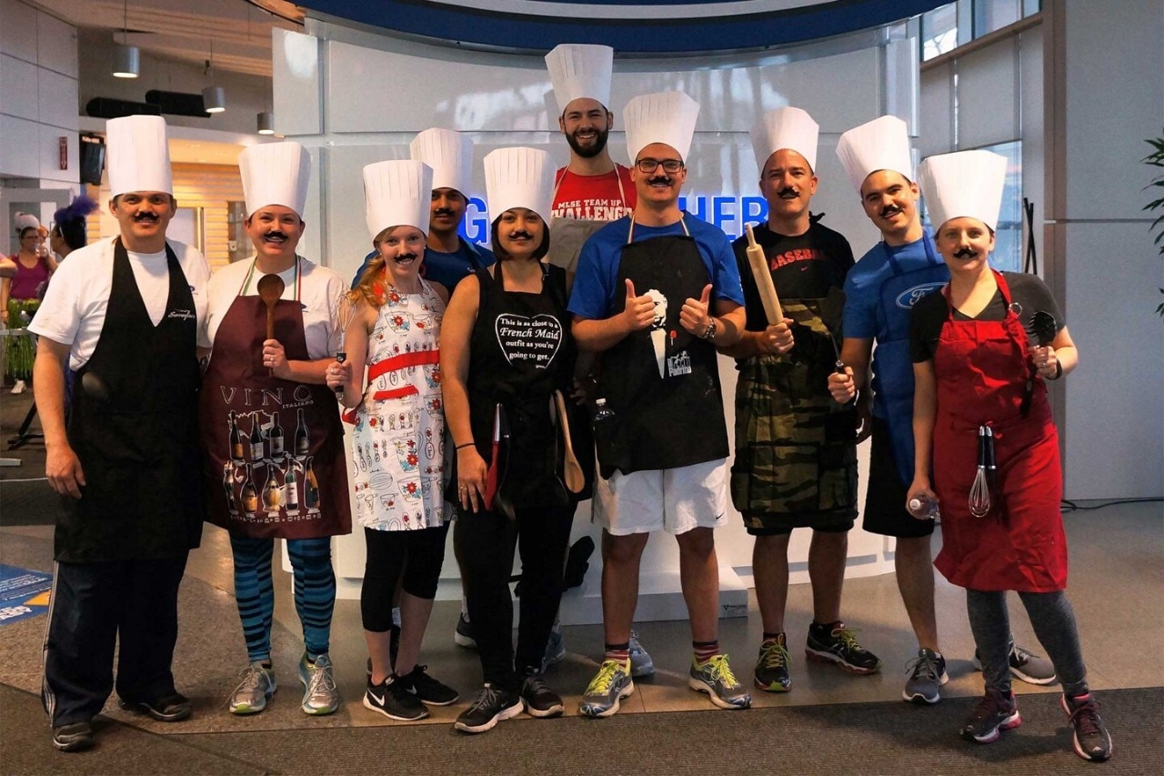 Ford employees wearing chefs hats at event