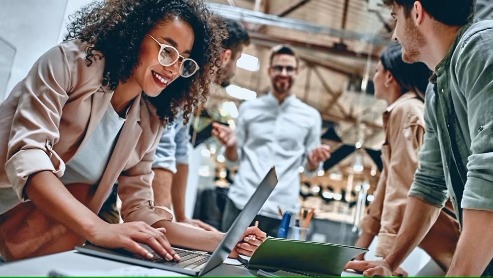 Employees collaborating around computer