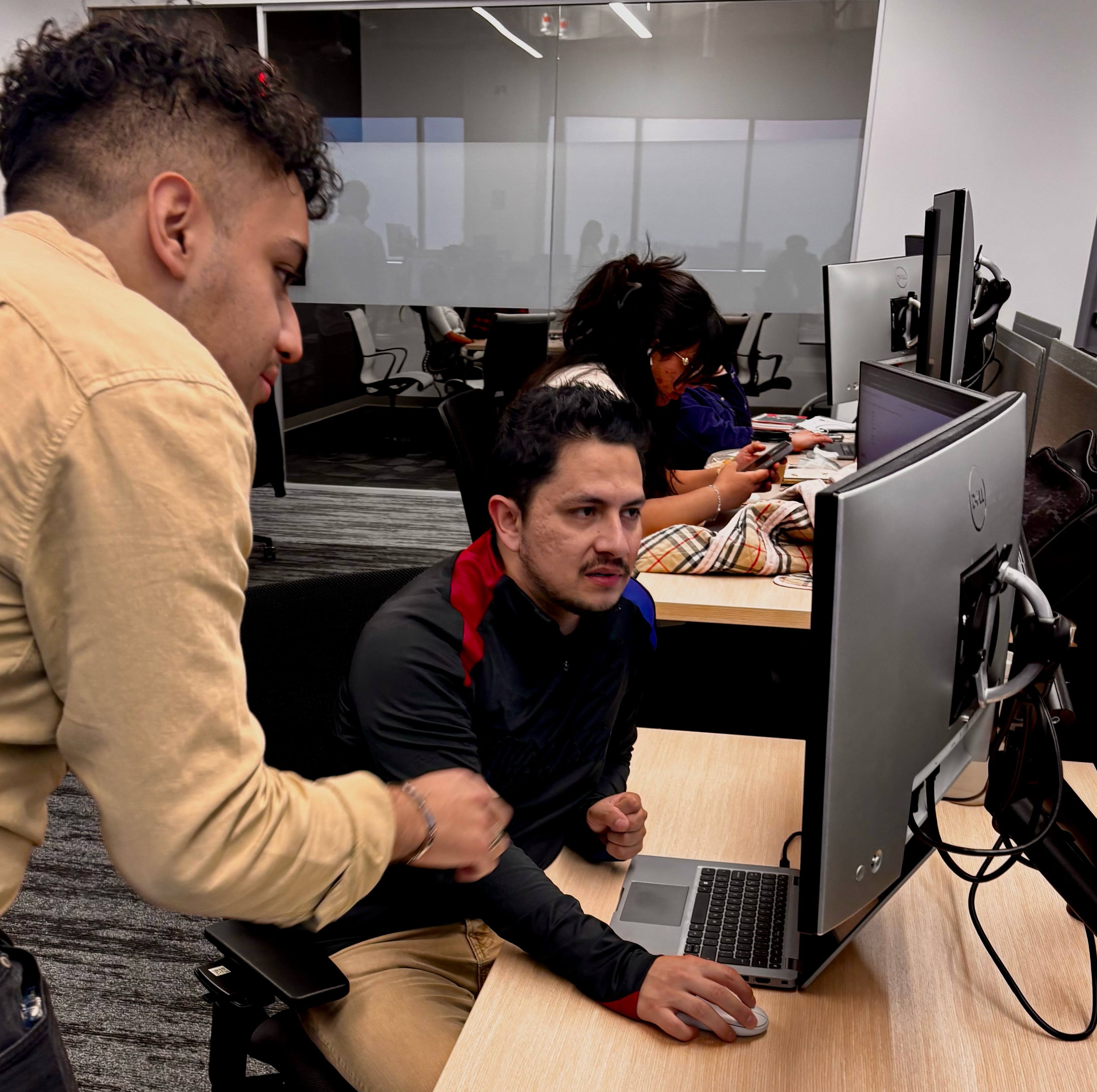 Several people working on laptops in an open office environment