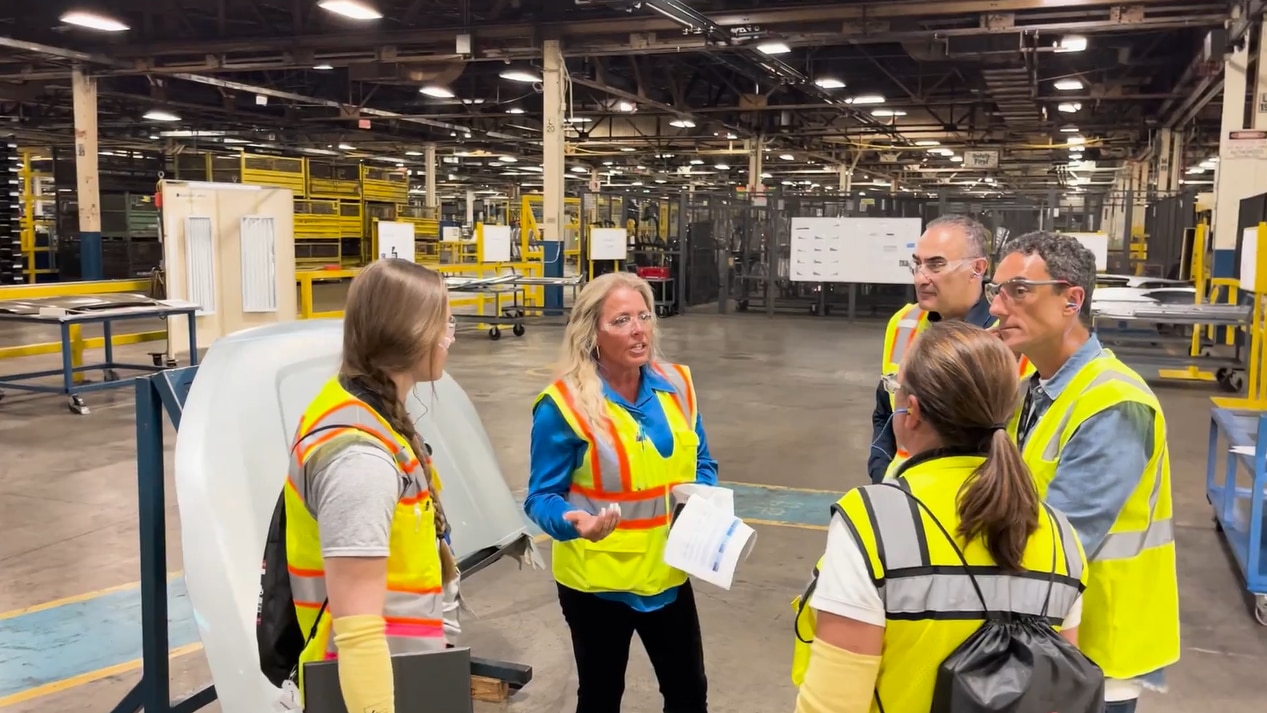 Employees in high visibility vests discussing plant operations