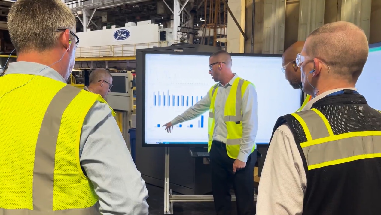 Employees in high visibility vests discussing plant operations