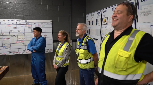 Employees in high visibility vests laughing