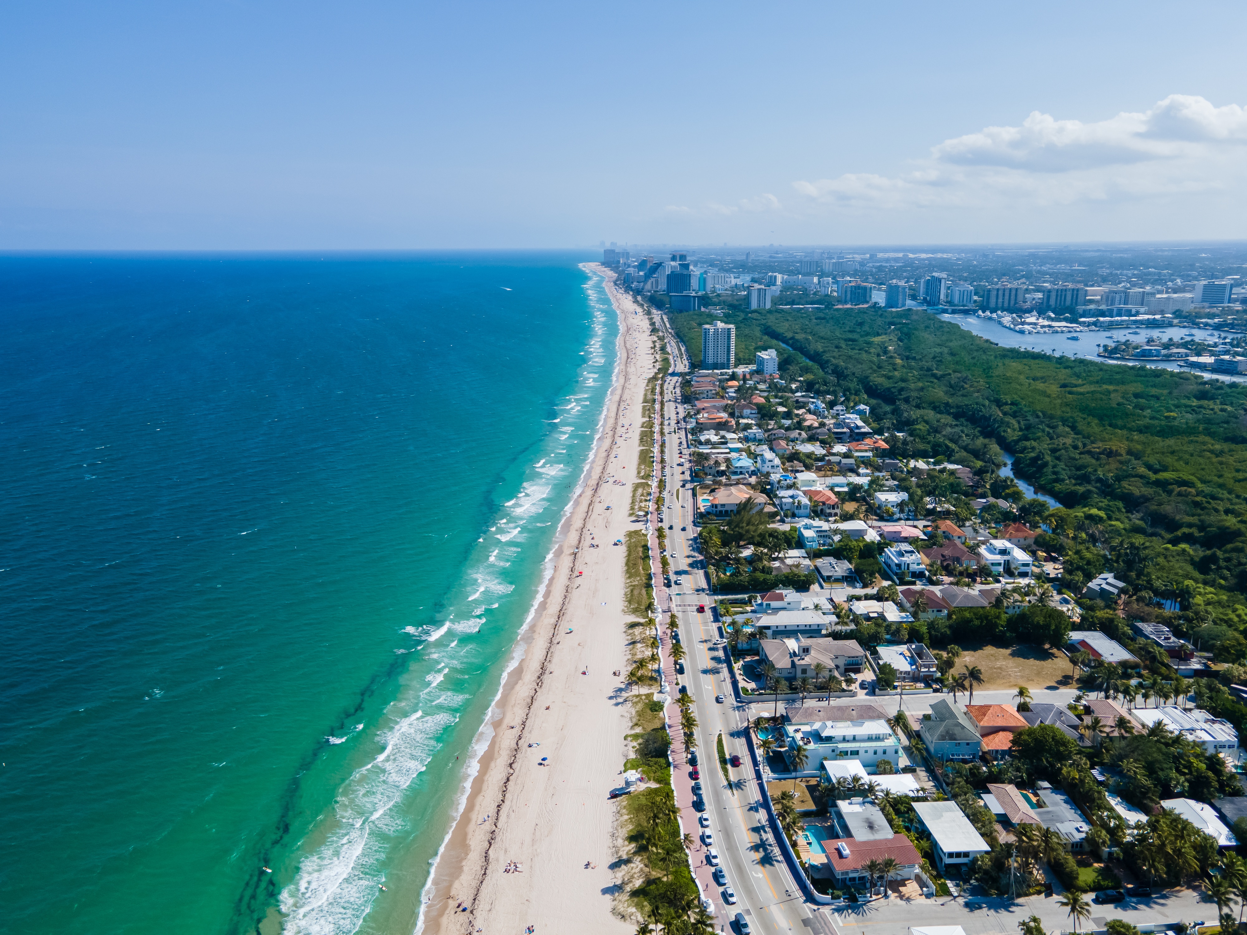 Aerial view showcasing vibrant Fort Lauderdale beach alongside a bustling city, highlighting the contrast between nature and urban life.