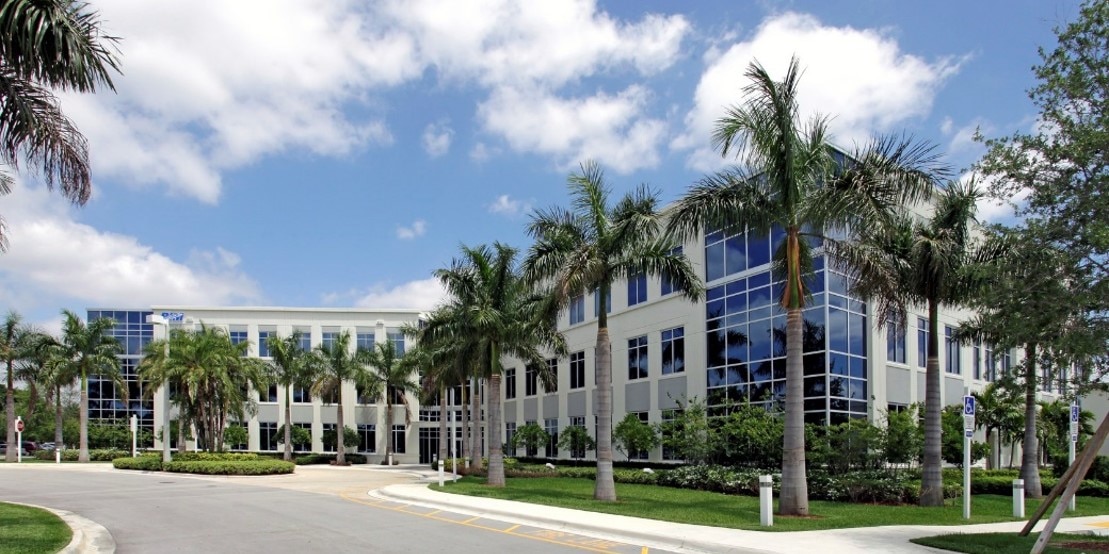 Office building at Sunrise Engineering Center, showcasing modern architecture surrounded by palm trees in Sunrise, Florida.